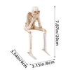 A set of three resin skeleton skull figurines displayed against a white background.