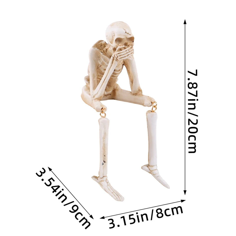 A set of three resin skeleton skull figurines displayed against a white background.