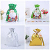 Five festive drawstring Christmas gift bags featuring Santa and snowman designs in green, pink, and gold.