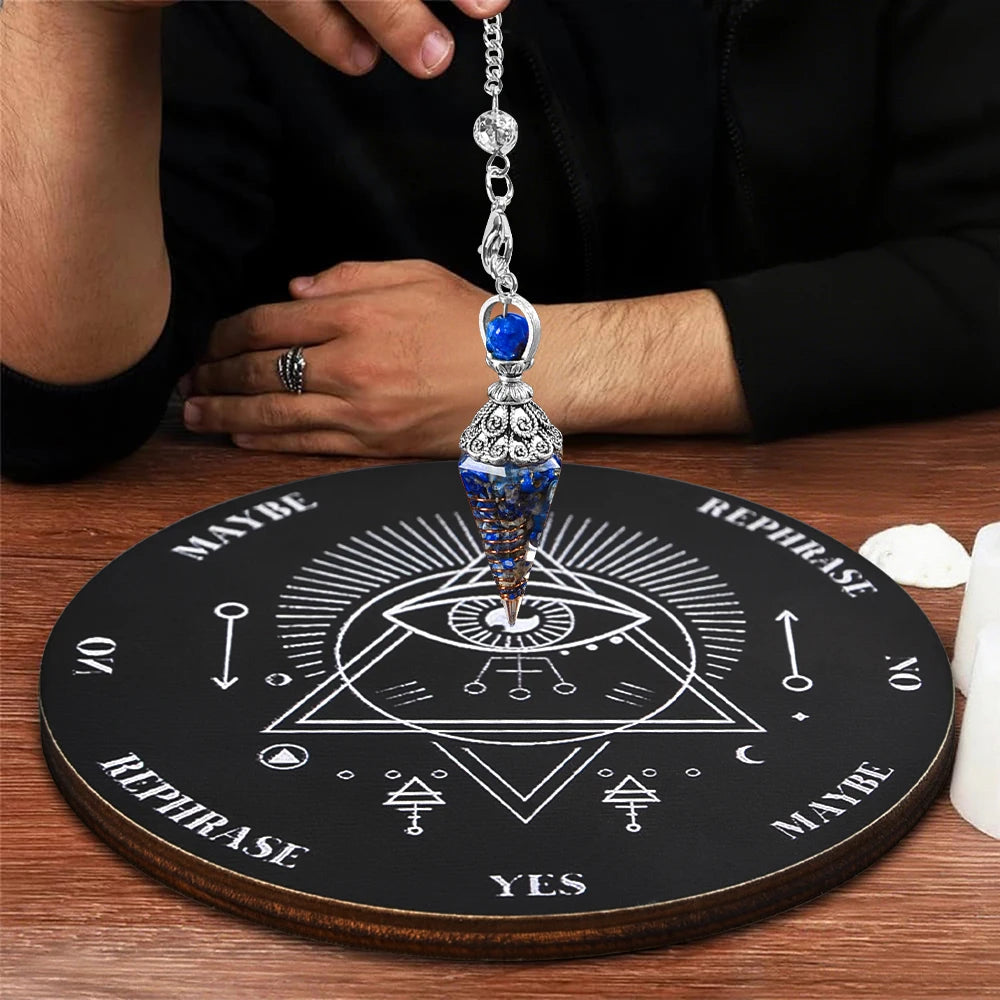 A crystal pendulum hanging from a chain rests on a wooden divination board with various symbols.