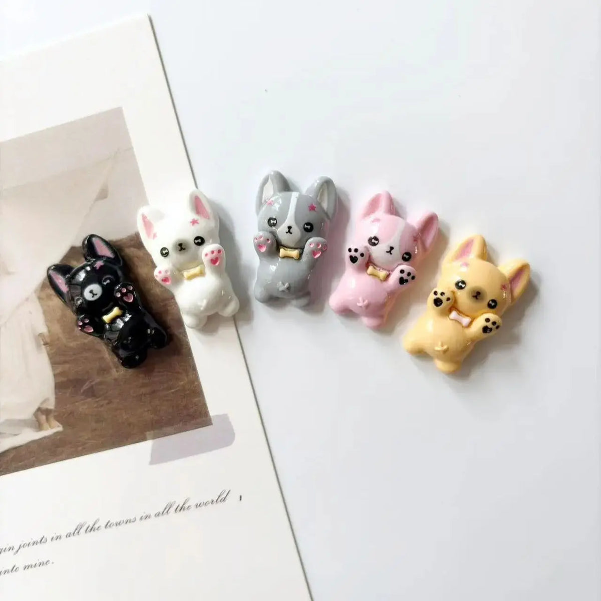 A set of mini puppy refrigerator magnets in various colors including black, white, gray, pink, and yellow.