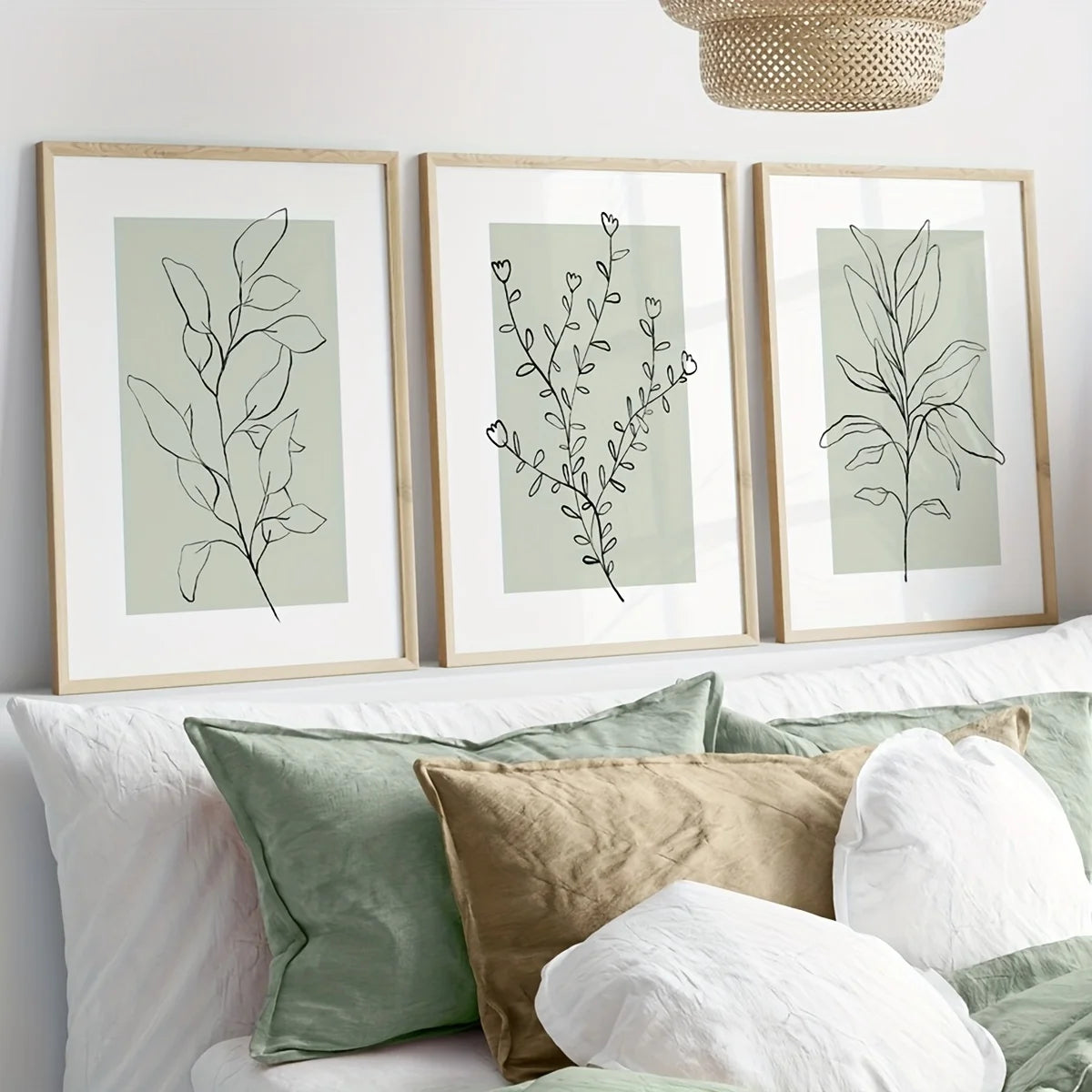 A set of three framed botanical prints featuring delicate olive branches in muted sage green and white on a light background.