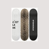 Three skateboard decks featuring white, leopard print, and black designs.