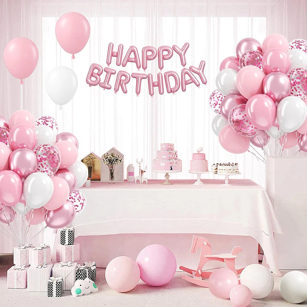 A display of pink and white latex balloons with metallic confetti accents set up for a birthday celebration.