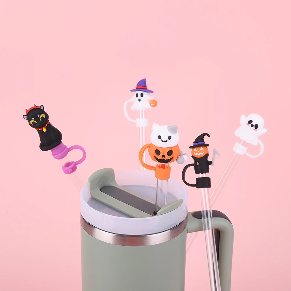 Reusable silicone straw covers shaped like Halloween ghosts and witches inserted into a reusable cup.