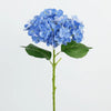 A branch of artificial blue hydrangea flowers with green leaves on a stem.
