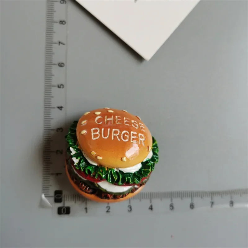 A homemade cheese burger sandwich with lettuce and tomato is placed on a ruler.