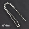 A white pearl rosary necklace featuring a vintage cross and Virgin Mary pendant.