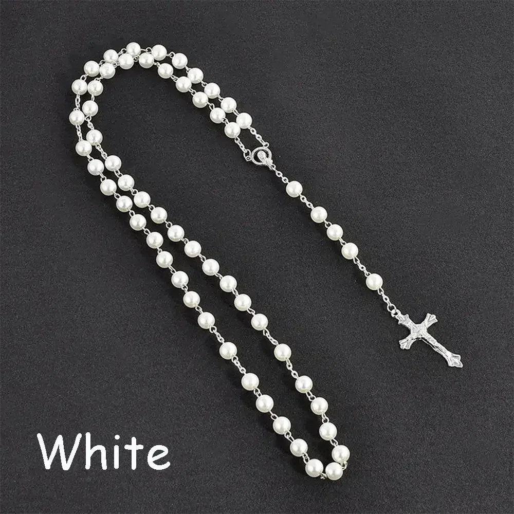 A white pearl rosary necklace featuring a vintage cross and Virgin Mary pendant.
