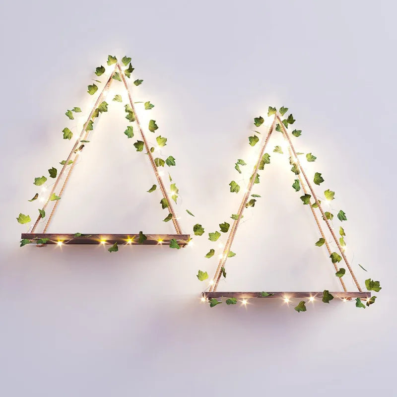Two geometric triangles made of thin branches adorned with glowing artificial leaves for home decor