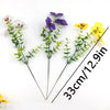 A small bouquet of artificial pansy and daisy flowers in purple, white, and yellow.