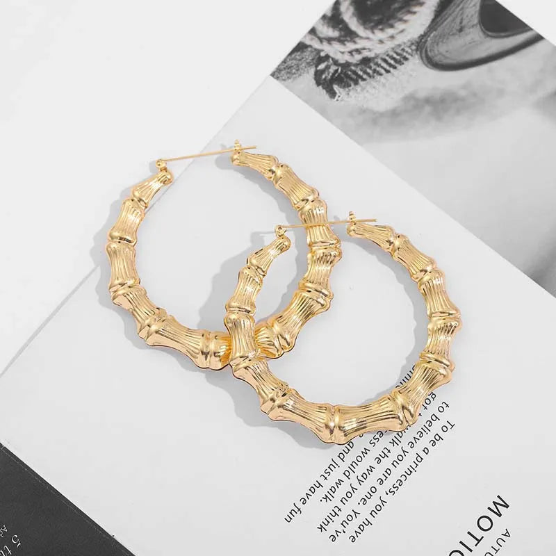 A pair of oversized bamboo hoop earrings in gold metal.