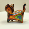 Hand-painted wooden sculpture of a kitten with vibrant, swirling stripes of color.