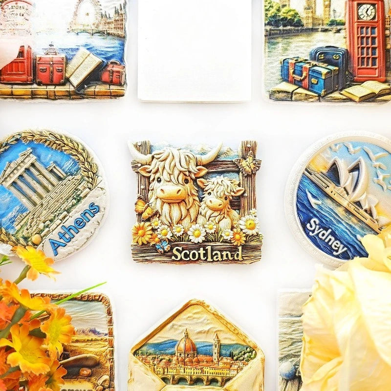 A collection of fridge magnets featuring Scottish Highland cows, an ancient Athens temple, and a cityscape.