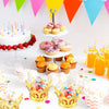 A display of gold crown candy boxes and various colorful candies on a white surface.