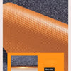 Close-up view of orange artificial grass carpet texture against a gray background.