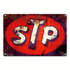 A vintage metal tin sign with the letters STP in white on a red circular background.