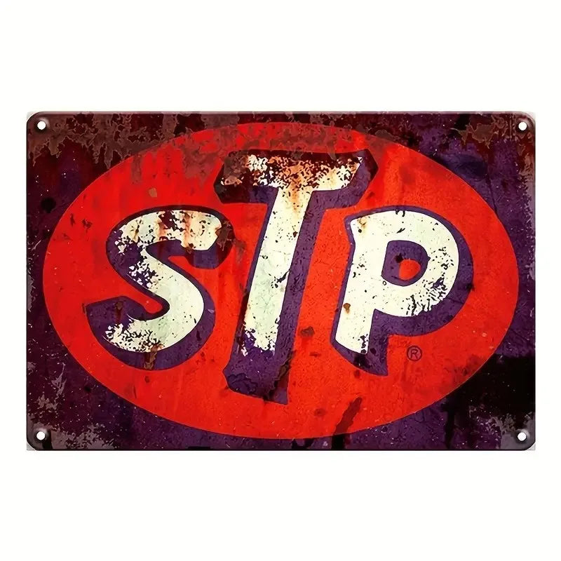 A vintage metal tin sign with the letters STP in white on a red circular background.