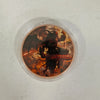 A circular coin design featuring a dark, menacing figure with wings and flowing hair against an orange and black background.