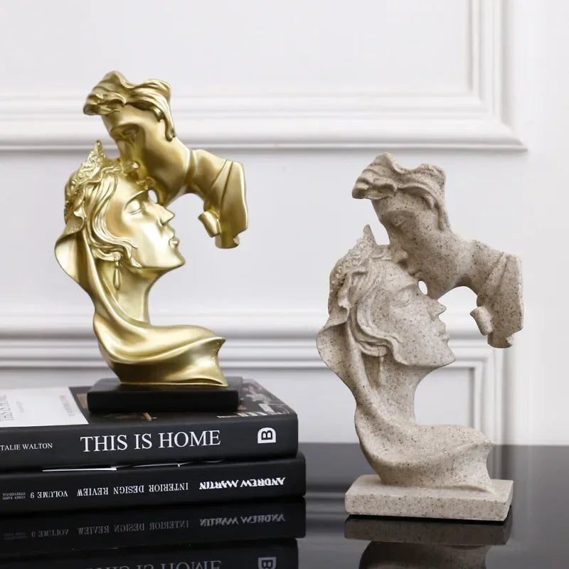 Statue en résine dorée d'un portrait féminin serrant un autre, exposée sur une pile de livres.