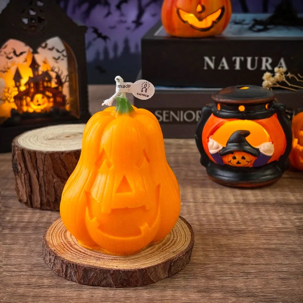 An orange Halloween smiling pumpkin silicone mold displayed on a wooden coaster with decorative candles in the background.