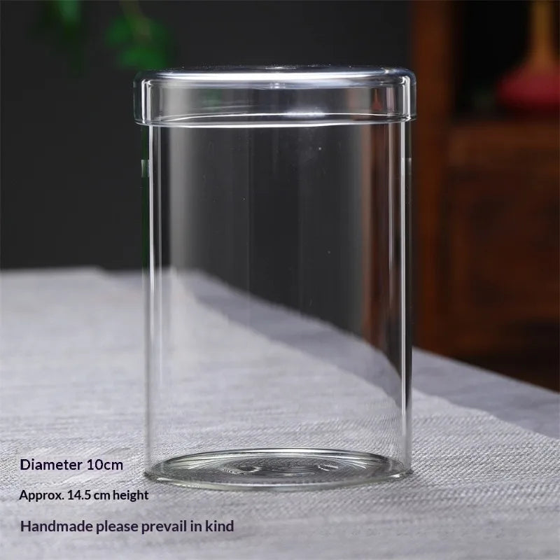 Clear glass cylindrical vase with a lid, approximately 10cm in diameter and 14.5cm high.