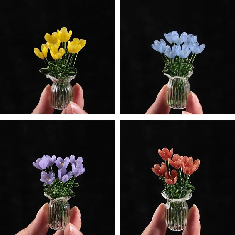 Three glass sculptures of flowers in yellow, blue, and pink hues held by hands.