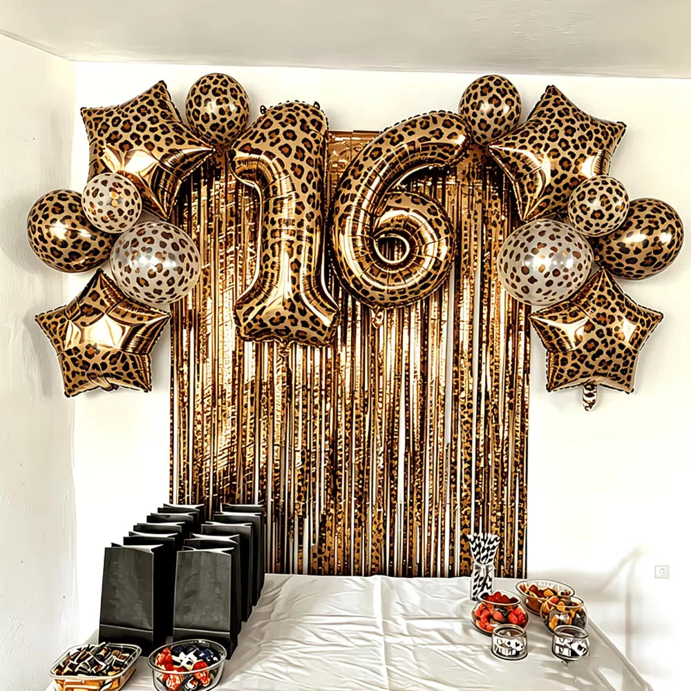 A display of leopard print star-shaped balloons hanging in front of a gold tassel curtain.