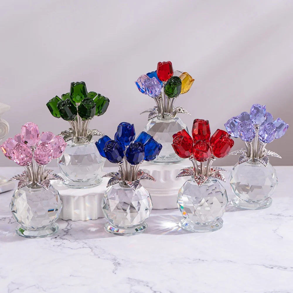 A collection of crystal rose decorative flowers in various shades of green, blue, and red displayed on a white marble surface
