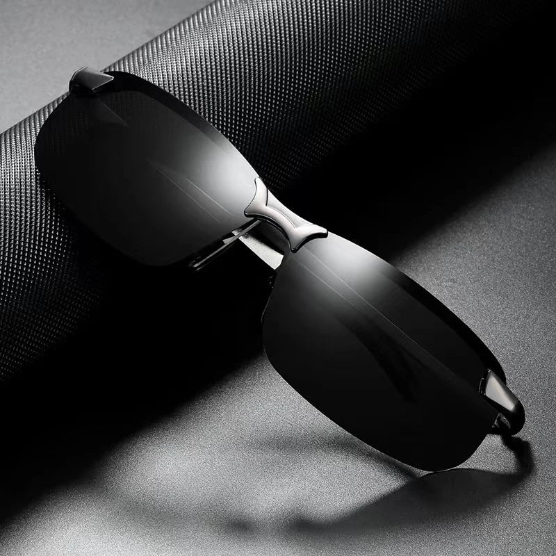 A pair of black photochromic polarized driving sunglasses with an alloy frame resting on a dark surface.