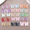 Variedad de cuentas de mariposa de vidrio coloridas en tonos rosa, púrpura, azul y naranja