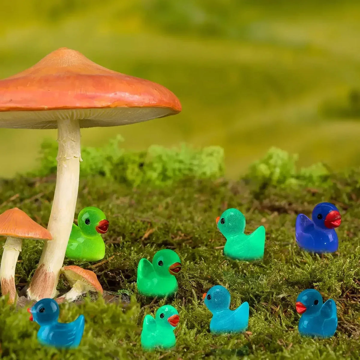 A collection of colorful mini duck figurines in various shades of blue and green resting on mossy ground.