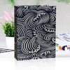 Nahaufnahme eines schwarz-weißen karierten Leinen-Cover-Fotoalbums mit kunstvollen wirbelnden Designs.