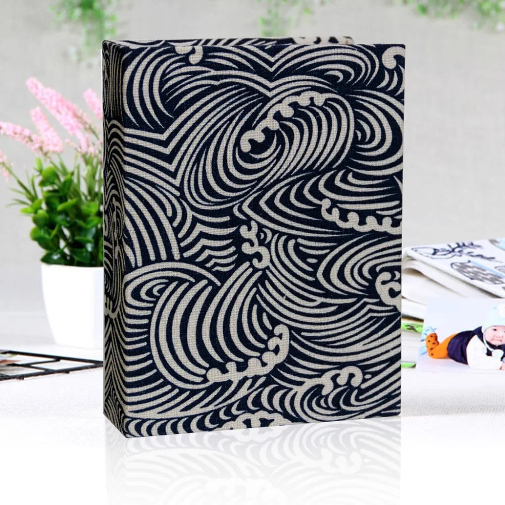 Nahaufnahme eines schwarz-weißen karierten Leinen-Cover-Fotoalbums mit kunstvollen wirbelnden Designs.