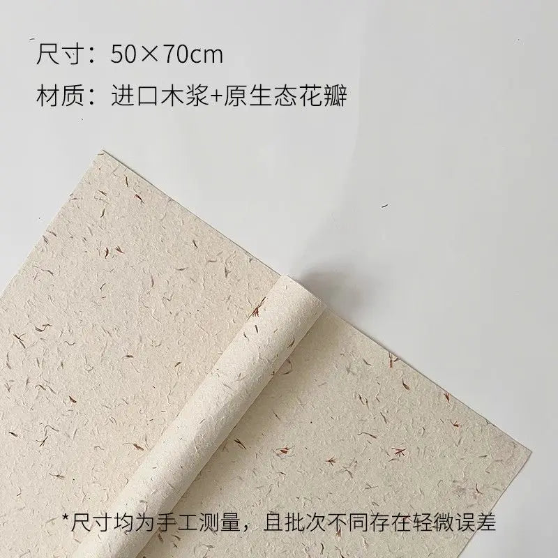 A roll of light beige decorative packaging paper with dried flower petals on it.