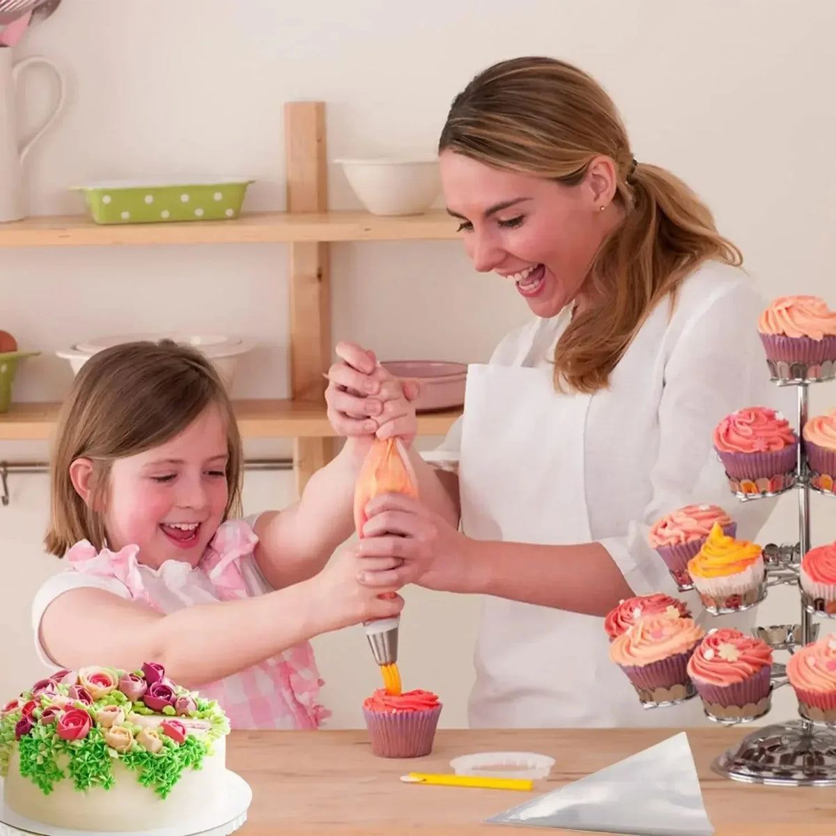 A woman is decorating a cake with a piping set, showing various colored frosting and tools.