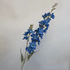 Une tige mince de fleurs de delphinium artificielles bleues avec de petites feuilles et bourgeons.