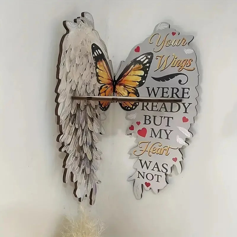 A decorative wall shelf featuring angel wings shaped like butterflies and text that reads Your Wings Were Ready But My Heart 