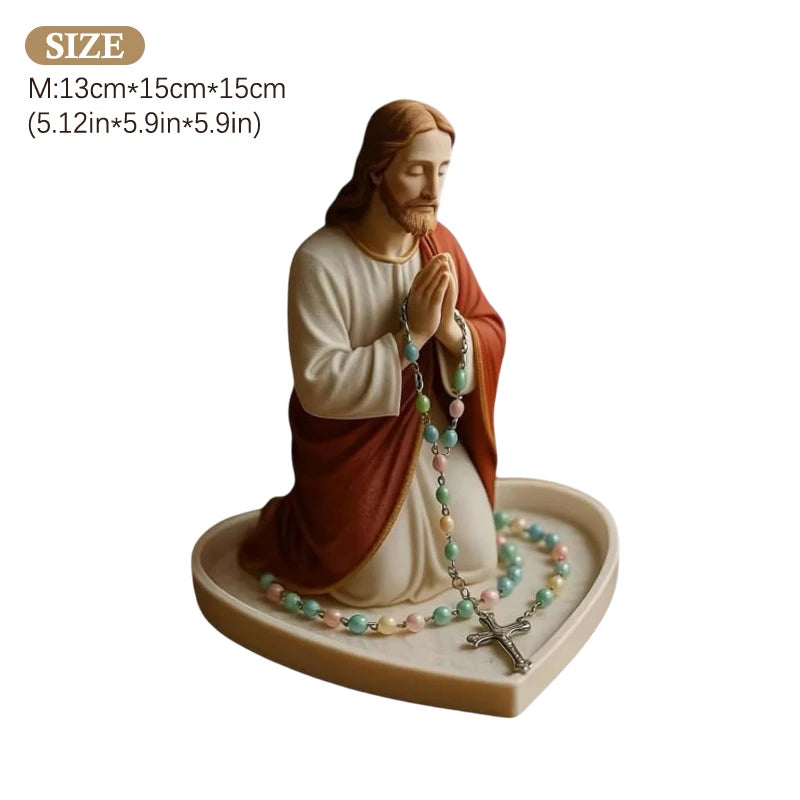 A statue of Jesus with a rosary holder and tray for devotion.