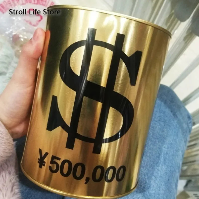 A hand holds a large gold-colored metal piggy bank with a black dollar sign and the text ¥500,000 printed on it.