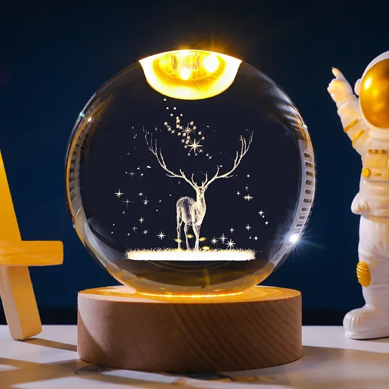 A glowing crystal ball night light featuring a deer silhouette on a dark background, resting on a wooden base.