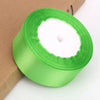 A roll of bright green satin ribbon used for crafts and gift wrapping.