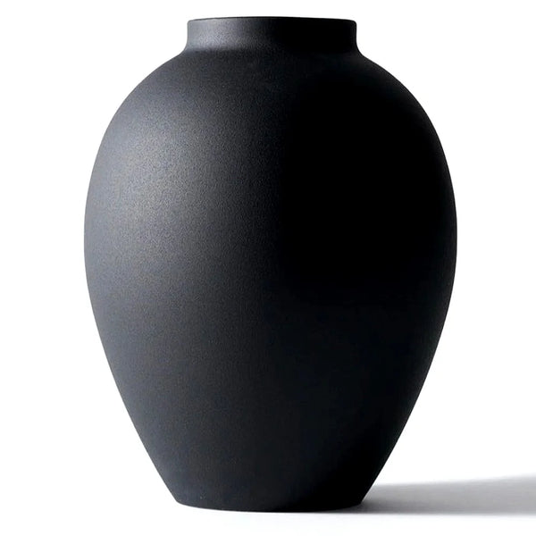 A smooth, matte black modern round metal decorative vase viewed from the side.