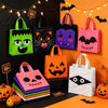 A set of reusable Halloween candy bags with handles in black, green, and pink colors displayed against an orange background.