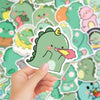 A hand holds a cute green dinosaur PVC sticker against a background of various pastel-colored dinosaur stickers.