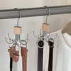 A set of multi-claw hangers with leather straps and wooden pegs hanging from a metal rod.