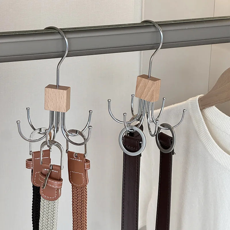 A set of multi-claw hangers with leather straps and wooden pegs hanging from a metal rod.