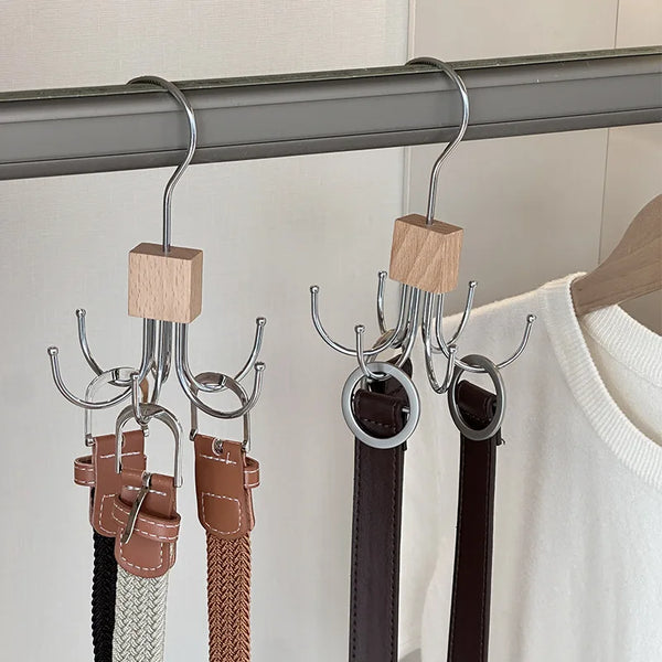 A set of multi-claw hangers with leather straps and wooden pegs hanging from a metal rod.