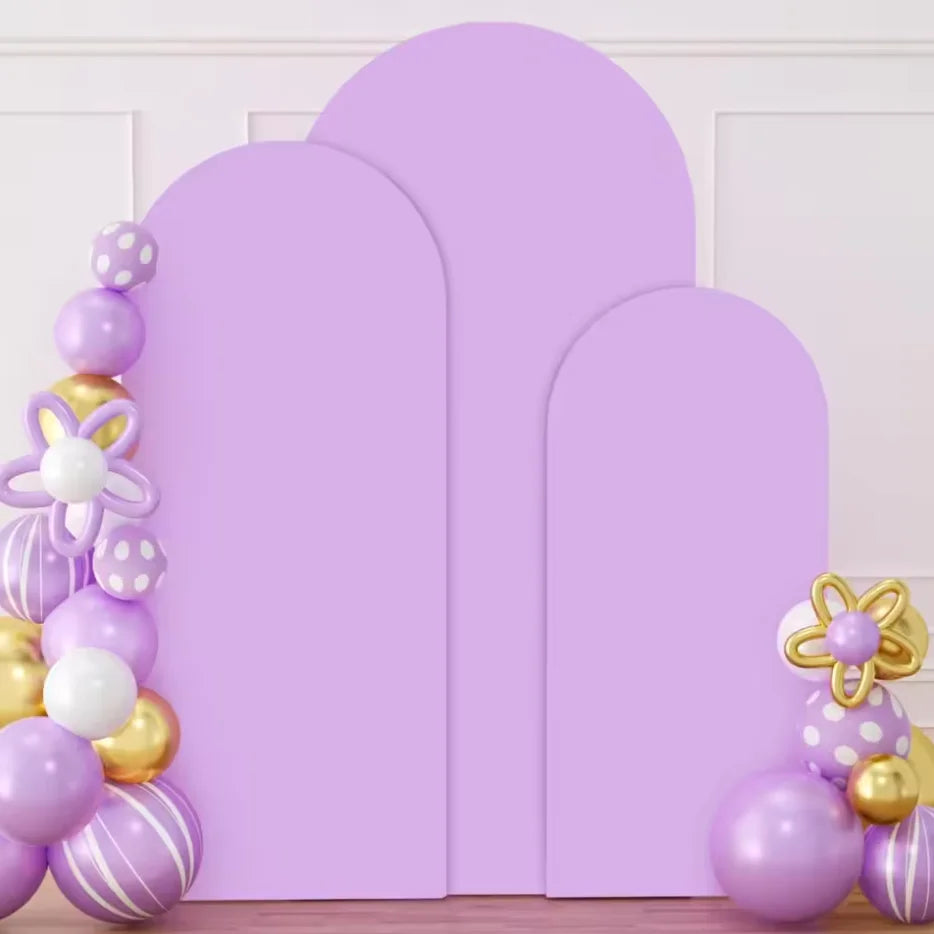 Three purple spandex wedding arch covers displayed against a white wall.
