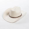A beige wool cowboy hat with a studded brown leather band shown from above.